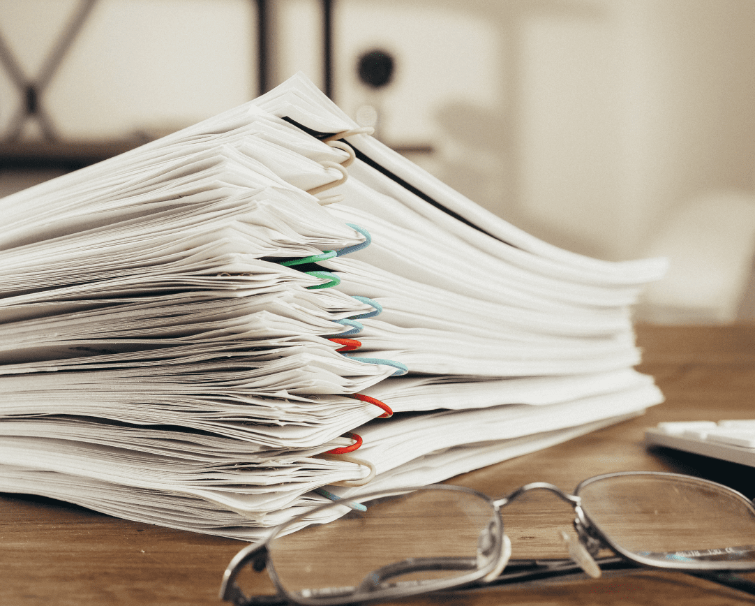 Close-up of stack of paperwork on table next to glasses